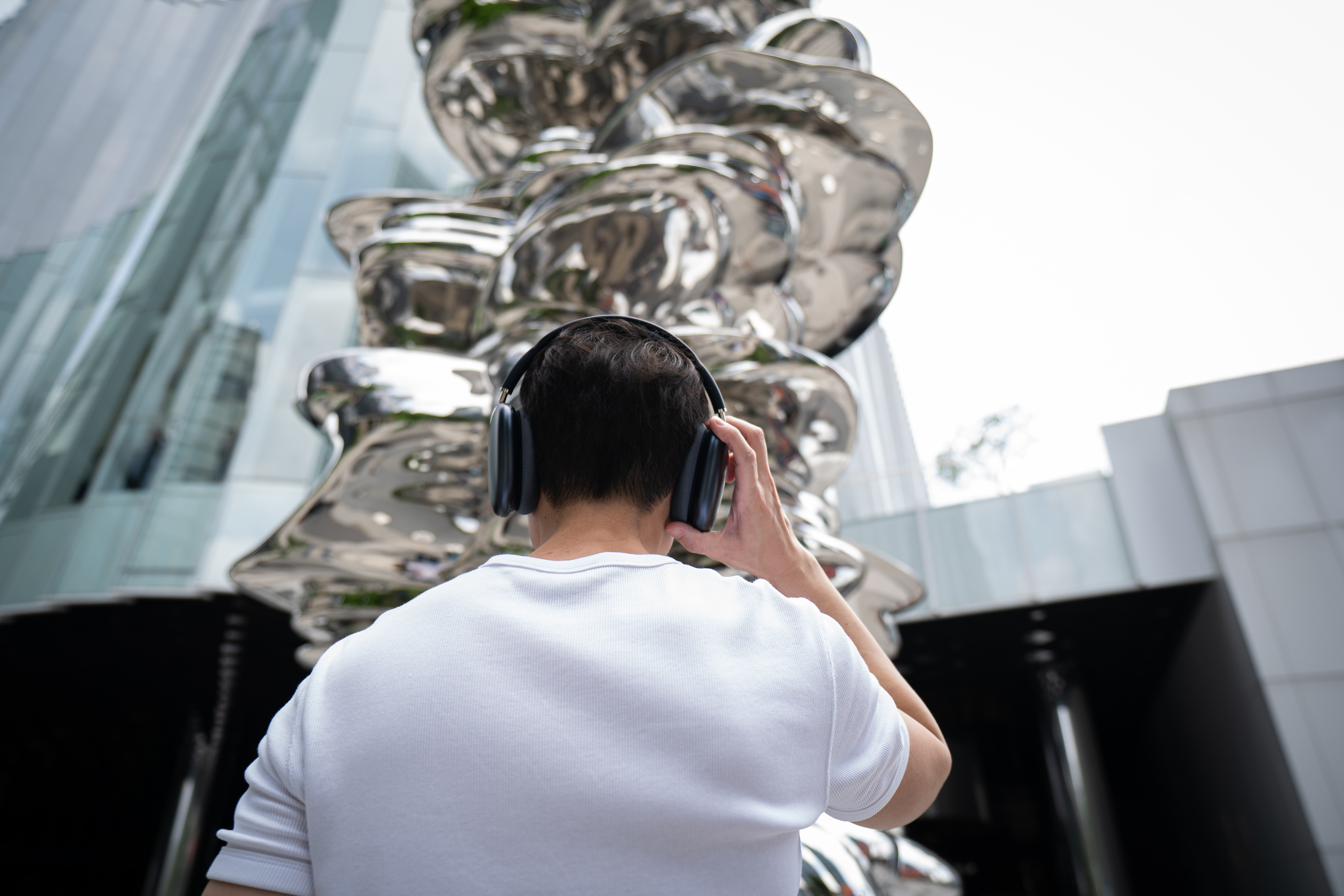 A young man wearing headphones to listen to One Bangkok Audio Guide.